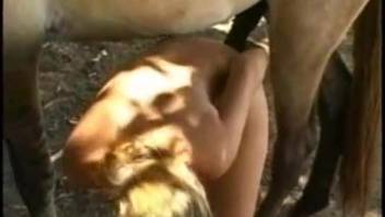 Blonde Latina leans forward to accept a stallion's penis
